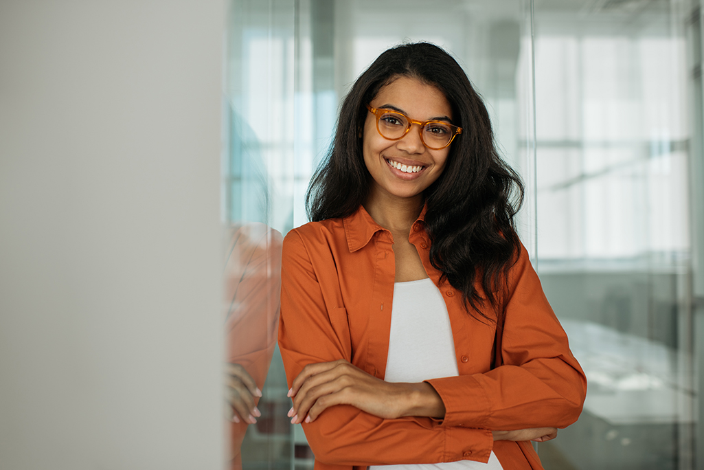 Confident woman in burnt orange dress shirt smiling