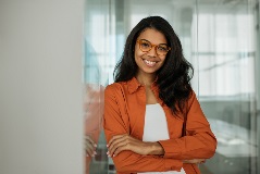Confident woman in burnt orange dress shirt smiling