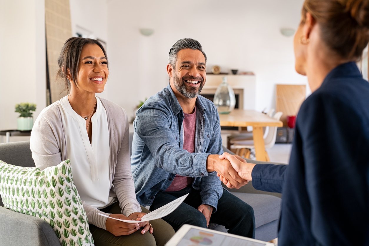 A visual minority couple shakes a CFP professional's hand