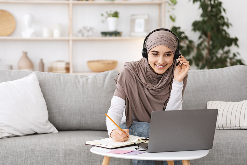Young woman with headscarf on a call from her laptop