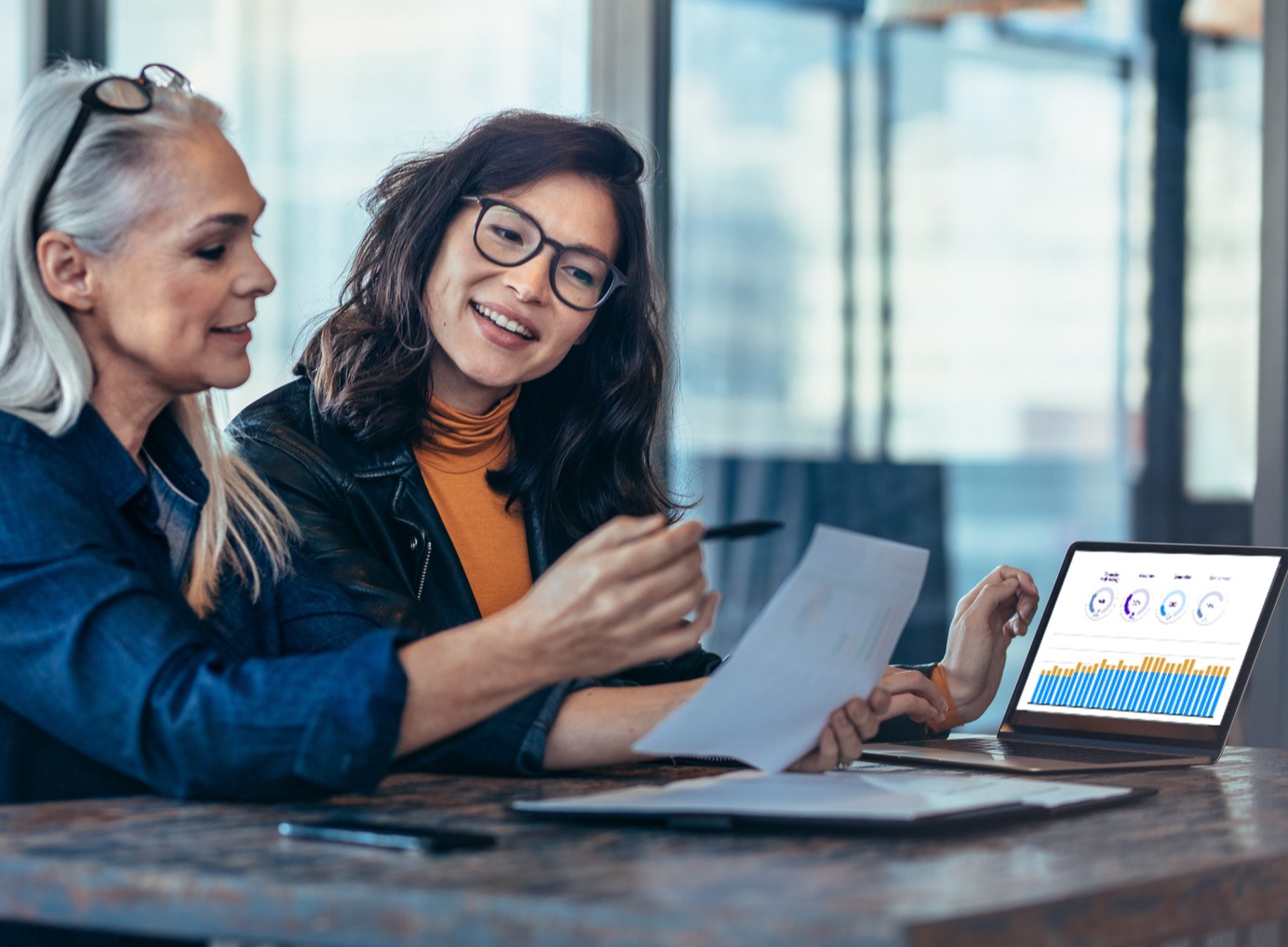 Two women reviewing Conquest software in an office