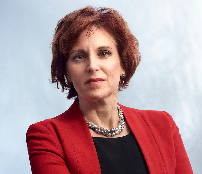 Tashia Batstone headshot. She is wearing a red blazer.
