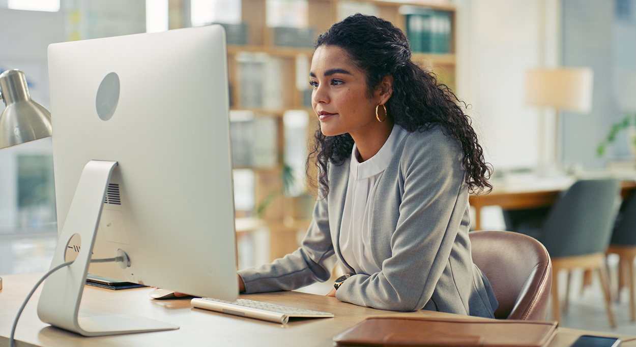 Woman sitting at a computer in open office environment