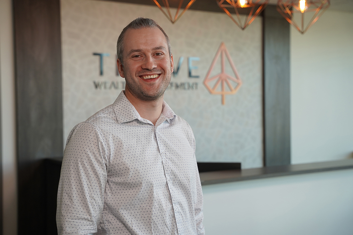 Evan Verbeem, wearing a white shirt and smiling.